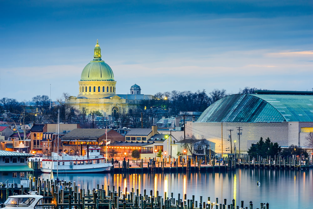 Aerial view of Maryland State House capitol building white dome and state circle with colonial houses in Annapolis on a sunny weekend afternoon