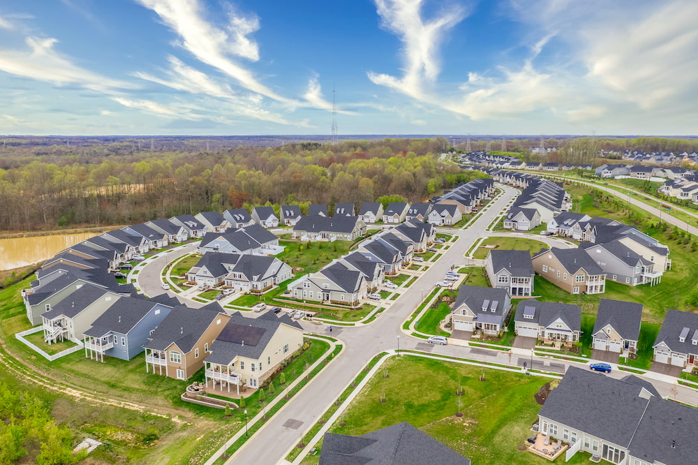 Aerial view of the geometrical curving American residential neighborhood, single family houses built close to each other with a cross street in Two Rivers Crofton Maryland with bue sky