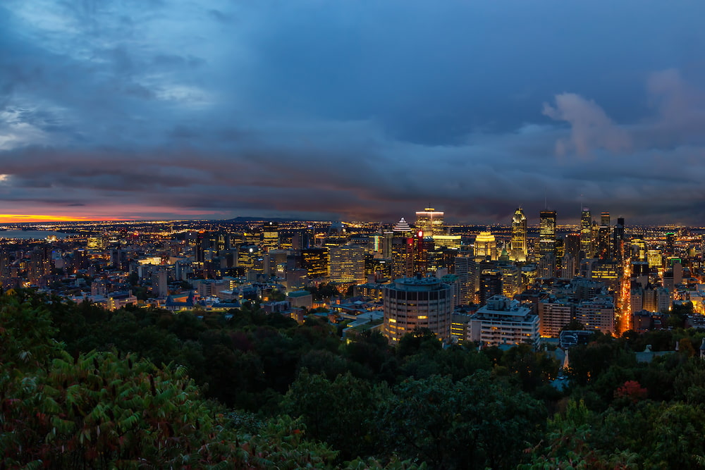 Panoramic aerial view of a magnificent modern city center at sunrise, dotted with clouds. Taken from Mount Royal in Montreal, Quebec, Canada.
